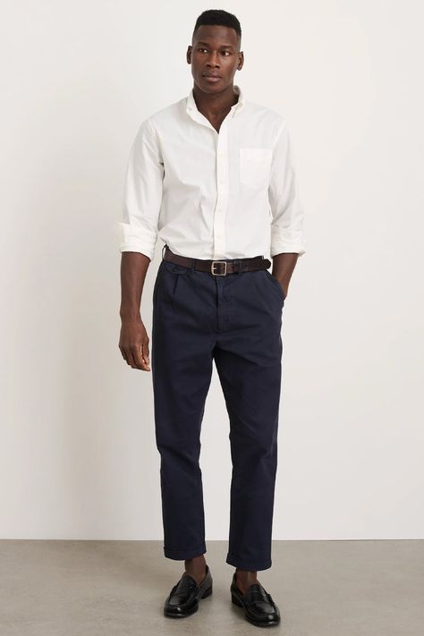 Men's cropped navy chinos, tucked in white shirt, brown leather belt and black leather penny loafers outfit. This outfit was included in the article: What Colours To Wear With Navy/Blue Pants: 8 Foolproof Shirt Options, on MensFlair.com Blue Pants Outfit Men, Navy Blue Pants Outfit, Navy Pants Outfit, Penny Loafers Outfit, Wedding Fits, Pleated Pant, Loafers Outfit, Navy Chinos, Pants Outfit Men