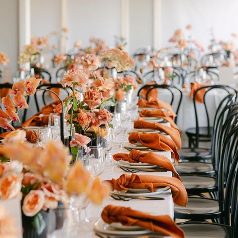 Repost: @lnr_events_ We did this by setting the table with impressive whisper weave linen, burnt orange napkins, black beautiful tableware, laminating peach taper candles, and elegant stationery, all complimented by lush florals in all the Autumn colours. Event stylist & management: @lnr_events_ Photographer: @neiyo Florist: @aschajolie Tableware: @eventmerchantco Table linen: @tablearteventhire Event stationery: @adelphimou Venue: @farmviganoweddings Orange Wedding Table Decor, Orange Table Setting, Long Wedding Table Decorations, Orange Napkins, Autumn Wedding Decor, Peach Decor, Elegant Stationery, Long Table Wedding, Event Stationery