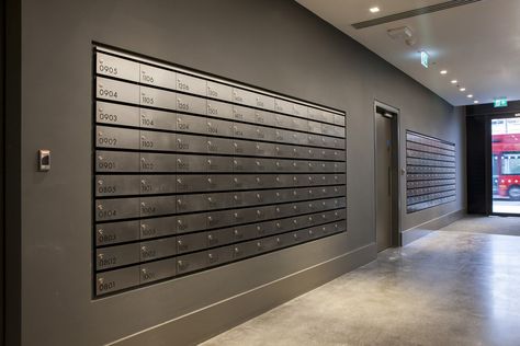 A large bank of horizontal stainless steel post boxes that are wall recessed in a passageway of high-end multi-occupancy residential development in London. Each mailbox has been engraved with a contrasting Jet Black infill that allows both residents and management staff to identify and use specific mailboxes as required. Mailroom Design, Apartment Mailboxes, Office Mailboxes, Stainless Steel Mailbox, Lobby Designs, Residential Lobby, Manhattan Loft, Mail Room, Mailbox Design