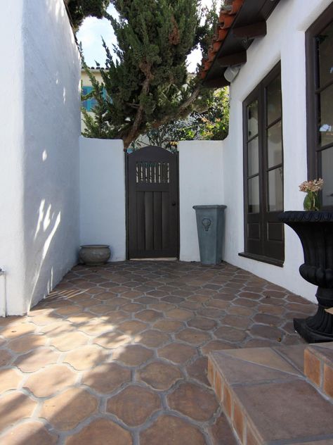 This Spanish-style kitchen courtyard forms an arresting study in contrasts. Terra-cotta-toned concrete pavers and red barrel roof tiles appear richer against pristine white walls, which in turn look luminous against the dark door and window casings. Mediterranean Courtyard, Perspective Architecture, Backyard Goals, Spanish Style Kitchen, Spanish Bungalow, Patio Tiles, Mediterranean Home Decor, Spanish Style Home, Casas Coloniales