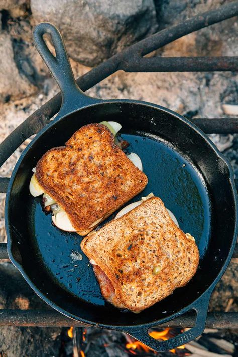 Upgrade your grilled cheese game with this apple, bacon, and cheddar sandwich. Cooked in a cast iron skillet over a campfire or your camp stove, this is the quick and easy hot lunch idea you’ve been waiting for. Campfire cooking | Camping food #camping Cheese Game, Grilled Sandwiches, Supraviețuire Camping, Bacon Grilled Cheese, Making Grilled Cheese, Camp Stove, Campfire Food, Grilled Sandwich, Fire Cooking