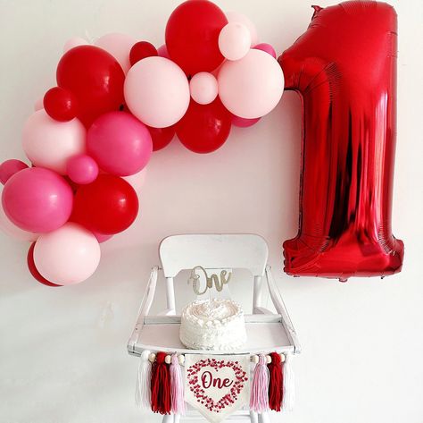 "For your Valentine baby who is turning one, this first birthday highchair banner is the perfect holiday flag to celebrate a milestone birthday.  A red and pink heart shaped frame made from tiny hearts surrounding the word \"one\" in a light red script font makes this flag a classic for their first celebration.  Banner includes 6 tassels in pale pink, red and white separated by wooden beads. Hang on a high chair or above the cake table and when the party is over hang on the wall as part of a room decoration.  This Valentine's Day love cake smash sign makes an awesome 1st birthday photo prop and keepsake. DETAILS Full banner: This 1st birthday banner comes with the center canvas banner with 2 pieces of attached double sided tape, 6 acrylic yarn tassels, and 6 wooden beads. It arrives alread Heart 1st Birthday Party, Love First Birthday Theme, Red Pink Party Decor, Our Little Sweetheart Is Turning One Decor, Heart Theme First Birthday, Valentines Themed First Birthday, Sweet One Valentines First Birthday, Valentines Birthday Photoshoot, Valentines One Year Old Birthday