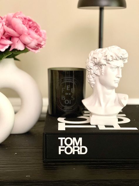 A beautiful console table styling idea with neutral and modern decor that features peonies, a Tom ford book, and luxury candle