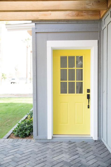 Paint an exterior door a fun yellow color to create a cheerful finish amongst neutral surfaces. Yellow Doors On Houses, Yellow Front Door Gray House, Peru House, Transitional Home Exterior, Yellow Front Door, Yellow Exterior, Front Door Ideas, Yellow Front Doors, Garage Door Types