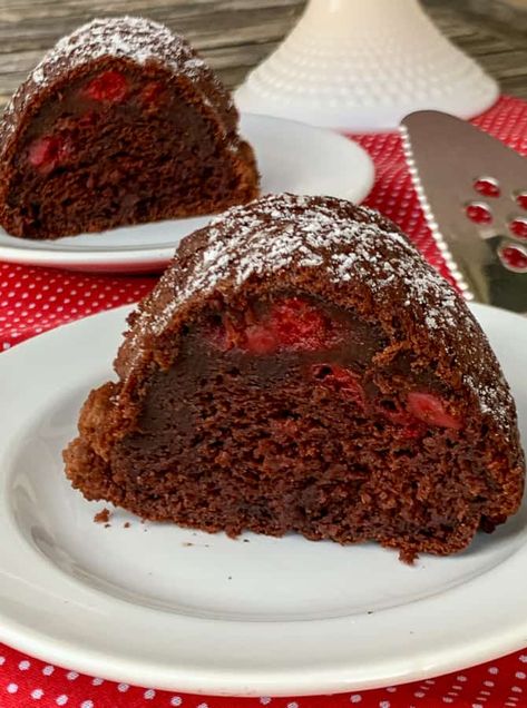 Slices of black forest cake on white plates and red napkin