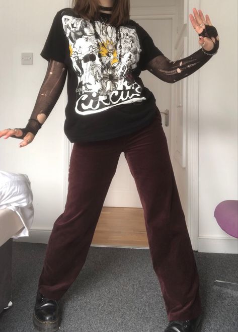 A mid-size person/girl wearing a black shirt with a white print-on, a black ripped tights top under it, dark red velvet pants, black platform dr. Martens and multiple crystal rings and bracelets. 	The person is also wearing multiple silver necklaces; one in form of a skull, a big cross, and one in form of a moon, a long black bead necklace and a black lace choker. Whimsigoth Outfits Pants, Casual Vampire, Fit Aesthetic Outfit, Whimsigoth Clothes, Thrifted Pants, Red Velvet Pants, Jewelry Cross Necklace, Fit Aesthetic, Funky Pants