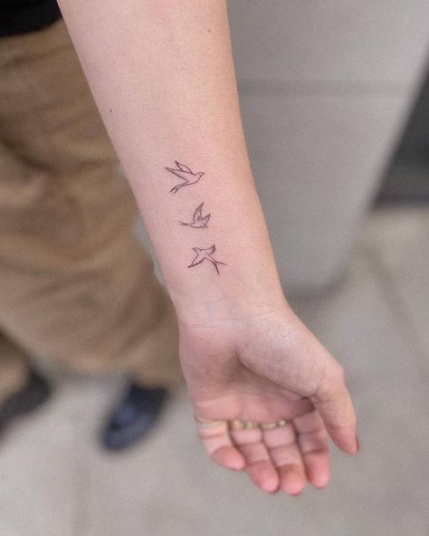 Fine line style flying birds tattoo located on the Swallow Tattoo Wrist, Flying Birds Tattoo, Bird Outline Tattoo, Swallow Tattoos, Swallow Tattoo Design, Bird Tattoos Arm, Swallow Bird Tattoos, Wrap Around Wrist Tattoos, Small Bird Tattoos