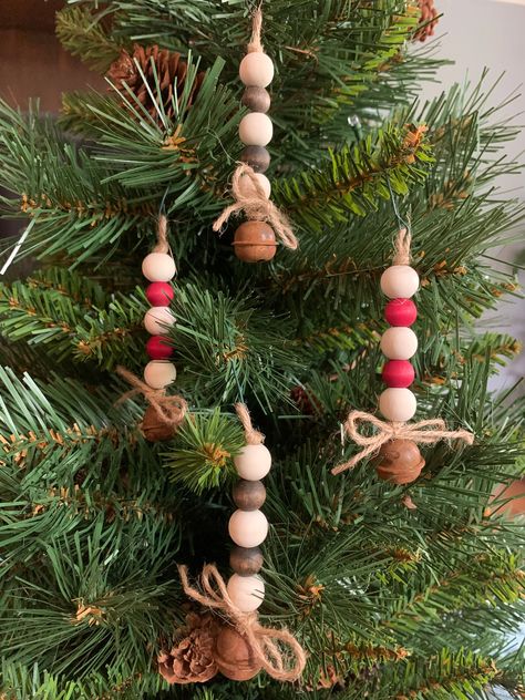 Thanks for stopping by! You're viewing one of my handmade sets of Christmas ornaments. Each ornament is made with 5 wooden beads and 1 "antique" bell. The beads can be colored with a dark brown stain, red or green dye or left natural.  Twine is used to string the ornament and a small loop is left at the top for hanging with a hook. Each ornament measures just over 3" tall plus ~.5" loop. Default bead colors are as shown in picture, i.e. 3 natural color beads with 2 colored beads mixed in (select the colored bead option in the Primary Color list). If you prefer a different mix of bead colors please be sure to include instructions in the Personalization section. I'll make every attempt to satisfy your request. Please note that each ornament is handmade and made to order. Please be aware that Diy Tree Ornaments, Christmas Party Crafts, Beaded Christmas Decorations, Antique Bell, Bazaar Crafts, Beaded Christmas Ornaments, Wooden Christmas Ornaments, Color Beads, Christmas Ornaments Homemade