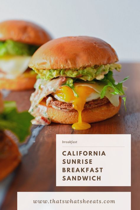 A breakfast sandwich stacked on a brioche bun with drippy egg yolk, avocado, mixed greens, and chicken sausage. Avocado Breakfast Sandwich, California Sunrise, Sunrise Breakfast, Brunch Burger, Breakfast Sandwich Recipes, Avocado Chicken, Breakfast Platter, Breakfast Burger, Frozen Berries