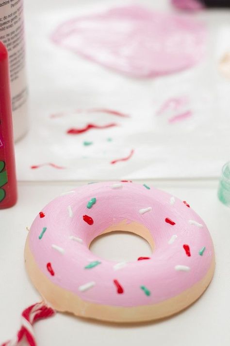 DIY Donut Ornaments You Need:  Donut Pan Plaster of Paris Disposable Tub/Tupperware for Plaster + Something to Stir With Twine Small Paper Clips Hammer Paint (one color for donut, one for frosting) Foam Brushes Puffy Paint (For sprinkles!) Donut Ornament, Diy Donut, Diy Christmas Candy, Diy Donuts, Candy Christmas Tree, Donut Decorations, Candy Tree, Candy Ornaments, Pink Icing