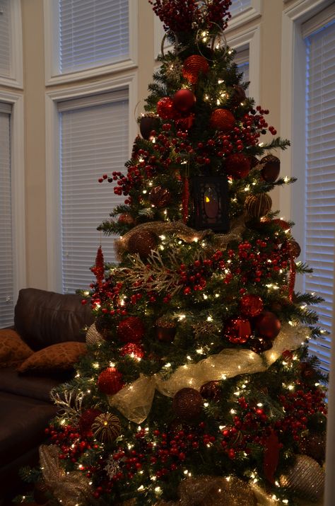 I used different shades of red, a dark brown, and antique gold. I also tied in some large lanterns. Red And Gold Ornaments On Tree, Red Gold Brown Christmas Tree, Christmas Tree Red And Brown, Dark Red And Gold Christmas Tree, Christmas Tree Dark Red, Red And Brown Christmas Decor, Maroon And Gold Christmas Tree, Brown And Red Christmas Decor, Deep Red Christmas Decor