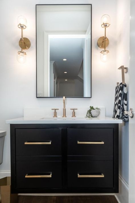 HGTV features a white powder room with a black vanity with gold-toned hardware, a black-framed mirror and gold-toned double sconces. Gold Bad, Bathroom Vanity Designs, Bad Inspiration, Black Vanity, Vanity Design, Gold Bathroom, Double Bathroom Vanity, Black Bathroom, White Bathroom