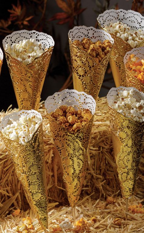 Whether you're celebrating #NationalPopcornDay or setting up a snack bar for a rustic wedding, this creative DIY popcorn display is sure to be remembered. How to: create cones out of gold foil doilies and secure shut. Push a skewer through the hole in the bottom of the cone so it comes about halfway through the cone. Fill with popcorn. Stick skewers in hay bails for a stand. Using different varieties of popcorn makes for a more fun looking display! Popcorn Display Ideas, Popcorn Display, Popcorn Store, Petite Desserts, Popcorn Ideas, Truffle Popcorn, Golden Bday, Popcorn Decorations, Christmas Banquet