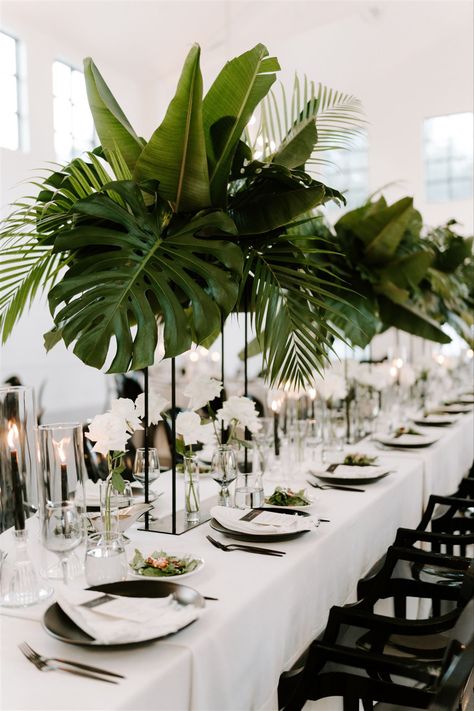 Wedding Flower Arrangements Tropical, Large Green Leaf Centerpiece, White Protea Arrangement, Monstera Plant Wedding Decor, Black White Gold Boho Wedding, Rainforest Themed Wedding, Plant Wedding Reception, Bali Inspired Wedding, Tulum Table Setting