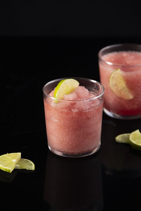 Two Frozen Cosmos, light pink in color, sit in glasses garnished by limes. Cosmo Cocktail, Frozen Cocktail, Frozen Cocktails, Slushies, Cocktail Recipe, Summer Heat, Drink Recipes, Cosmopolitan, Cocktail Recipes