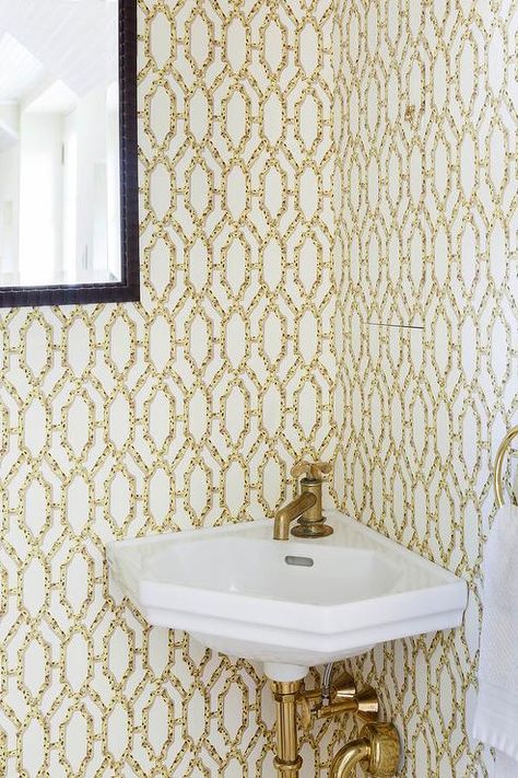 White and yellow powder room features walls clad in yellow bamboo wallpaper lined with a corner sink fitted with a brass faucet. Yellow Powder Room, Blue Powder Rooms, Tiny Powder Rooms, Tiny Powder Room, Corner Sink Bathroom, Bamboo Wallpaper, Powder Room Sink, Yellow Bamboo, Deco Bathroom