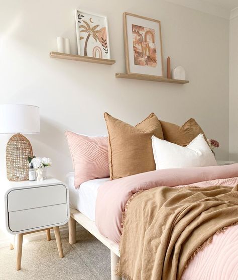 A pretty combination of beige and light pink bedding inspires a light design in this subtle bohemian bedroom. If you display artwork in this type of space, choose images with organic shapes and matching colors to highlight the softness of the room's design. Let simple wood shelves host decorative pieces to enhance white walls. Colorful Bedroom Design, Fireplace Accent Walls, Bed Frame Sets, Simple Bedside Tables, White Subway Tile Backsplash, White Shaker Cabinets, White Kitchen Island, Dark Furniture, Patterned Bedding