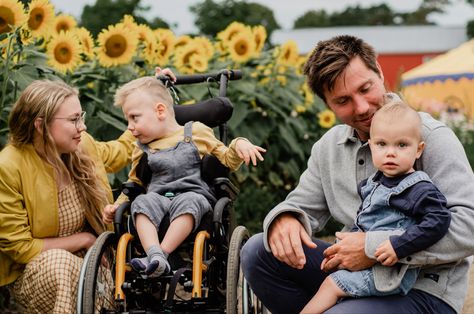 A family, mom sitting next to the son on a wheelchair, dad holding a child on the lap on a background of sunflowers Family Pictures With Wheelchair, Wheelchair Photoshoot, Family Sunflower Photoshoot, Wheelchair Photography, Sunflower Photoshoot, Lauren Taylor, Photoshoot Family, Fall Pictures, Family Photoshoot