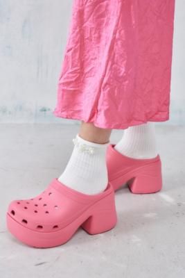 Stomp around in statement clogs by Crocs. The Siren is a bold update on the classic rubber clogs, complete with a platform sole, a curved silhouette and a stacked block heel. Features an open heel, a round toe and breathable holes for customising with your favourite Jibbitz. **Content + Care** \- 100% Rubber \- Spot clean | Crocs Pink Siren Heeled Clogs - Pink UK 6 at Urban Outfitters Clog Crocs Outfit, High Heel Crocs, Nicki Concert, Clean Crocs, Clog Crocs, Platform Crocs, Crocs Outfit, Crocs Slides, Heeled Clogs