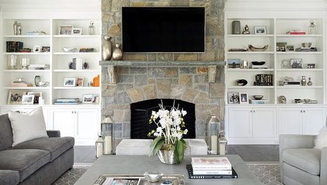 Gray living room features a gray velvet sofa lined with white pillows facing a pair of dove gray accent chairs across from a gray cocktail table. Built In Around Fireplace, Country Fireplace, Shades Of Silver, Traditional Family Room, Fireplace Seating, Fireplace Bookshelves, Built In Shelves Living Room, Living Room Built Ins, Fireplace Shelves