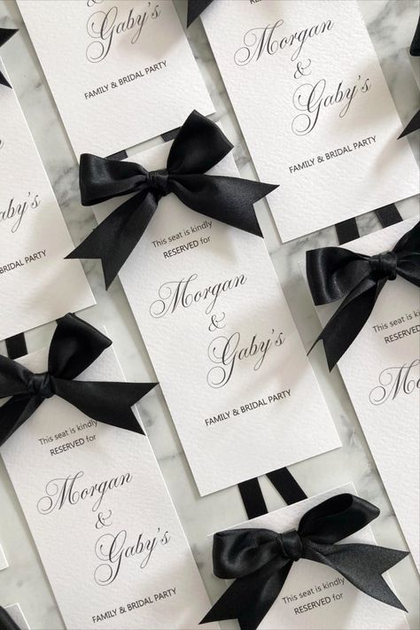 Flat lay of a series of Reserved seating tags printed in black onto white textured card with a black satin bows at the top of the cards. Shown against a grey marble background Wedding Reserved Seating, Reserved Seating Wedding, Sign For Wedding, Reserved Seating, Wedding Name Cards, Wedding Name, Black Tie Wedding, Satin Bow, White Card