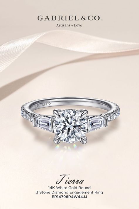 This unique 3 stone engagement ring is embellished with a pair of tapered baguette side stones, set horizontally beside a round center stone. ER14796R4W44JJ #GabrielJewelry #EngagementRings #WhiteGoldEngagementRings #RoundEngagementRings #ThreeStoneEngagementRing Ring Book, Baguette Side Stones, Gabriel Jewelry, 3 Stone Engagement Ring, Book Appointment, 3 Stone Engagement Rings, Round Engagement Rings, Stone Engagement Ring, Three Stone Engagement Rings