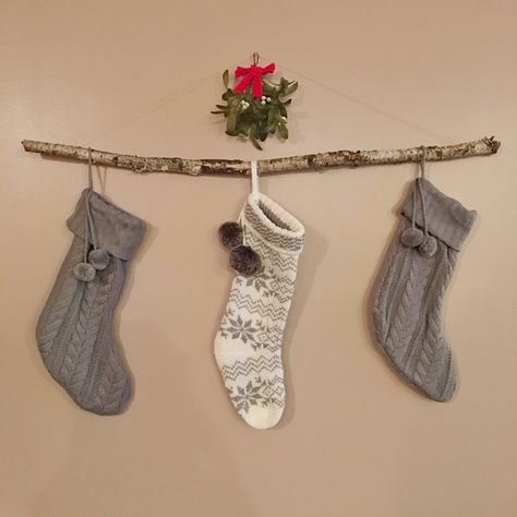 A simple birch branch and some mistletoe add a rustic touch to hanging stockings. Branch Stocking Holder, Tree Branch Stocking Holder, Stocking On Wall Ideas, Diy Stocking Holder, Merry Chrysler, Stockings Diy, Branches Diy, Diy Stockings, Christmas Stockings Diy