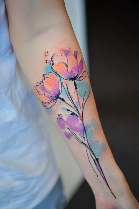 Watercolor-style tattoo of colorful flowers on a person's forearm. Water Color Tattoo For Girl, Tattoo Ideas Colorful, Watercolor Tattoo Design, Watercolor Flower Tattoo, Watercolor Phoenix Tattoo, Watercolor Heart Tattoos, Watercolor Wolf Tattoo, Luna Moth Tattoo, Watercolor Tattoo Tree