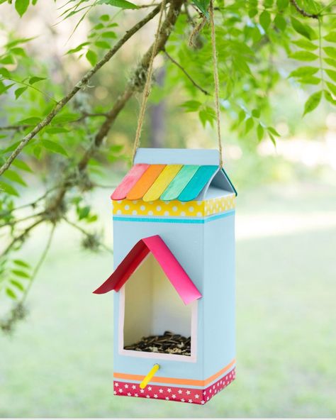 a milk carton decorated with paper washi tape and colorful popsicle sticks turned into a bird feeder hanging from a branch Milk Carton Bird Feeder, Bird Feeders For Kids To Make, Roadside Stand, Bird Feeder Craft, Easy Bird, Diy Bird Feeder, Diy Birds, Milk Carton, Toddler Fun