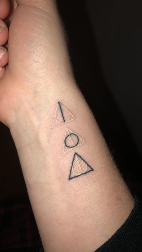 Harry Potter Deathly Hallows tattoo with white and black ink. Showing the elder wand, the resurrection stone, and the invisibility cloak in parts. Harry Potter Deathly Hallows Tattoo, Resurrection Stone, Hallows Tattoo, Tattoo Harry Potter, Hogwarts Tattoo, Harry Potter Symbols, Interesting Tattoos, Wand Tattoo, Stone Tattoo