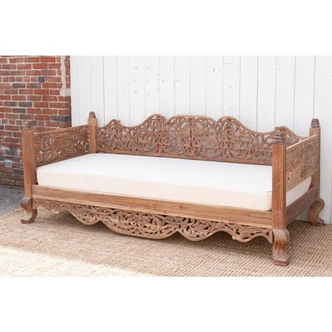 This finely carved Anglo-Indian daybed is crafted from reclaimed teak and boasts a natural aged patina, whispering tales of its sustainable origins. Anglo-Indian design reflects a fascinating blend of Indian craftsmanship and British colonial influences. This wooden daybed exemplifies this fusion perfectly. The exaggerated curves of the apron and back, for instance, are a characteristic Anglo-Indian feature, often seen in contrast to the straighter lines favored by British design at the time. Th Daybed Pillow Arrangement, Mughal Interior, Dewan Sofa, Day Bed Ideas, Balinese Furniture, French Style Sofa, Carved Wood Furniture, Lounge Mood Board, Daybed Pillows