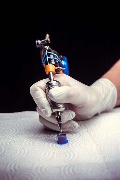 Premium Photo | Hand of a tattoo master with a tattoo gun. hand of a tattoo specialist and a tattoo gun.|#tattoo #handtattoo #tattoos #tattooartist 1106 Hand Holding Tattoo Machine, Tattoo Artist Photography, Tattoo Artist Business Cards, Tattoo Tools, Background Tattoo, Tattoo Poster, Tattoo Posters, Tattoo Techniques, Tattoo Background