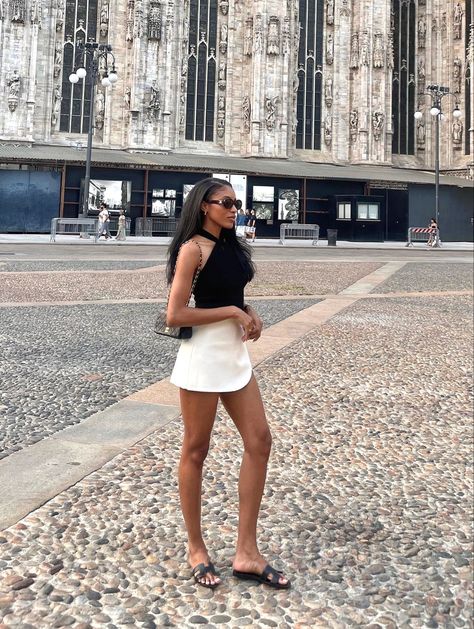 ✨Black halter top white a-line mini skirt summer outfit. Black Hermès oran sandals outfits. Classy black women aesthetic. Black sunglasses. Black & white summer outfit ideas. Downtown walking summer outfits @Rem0nia ✨ #taylajaybeauty #style #outfits #taylajay #summer #hermes #sandals #aline #halter #summerstyle #blackandwhite #downtown #classy #sunglasses #handbags #hair Outfits With Hermes Sandals, Black Hermes Oran Sandals Outfit, Hermes Sandals Outfit Street Styles, Hermes Oran Outfit, Hermes Sandals Outfit, Hermes Oran Sandals Outfit, Mini Skirt Summer Outfit, Classy Black Women, Dinner Outfit Summer