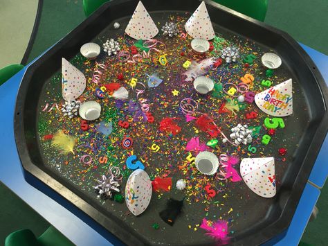 Birthday tuff spot. Includes a party hat for each child, glitter, star sequins, number 5's, cup cake cases, candles, coloured wood chip, spinning tops, Pom Poms, feathers and birthday ribbons! #tuffspot #tufftray Birthday Party Eyfs Activities, Eyfs Birthday Activities, Birthday Eyfs Activities, Birthday Topic Eyfs, Tuff Tray Party Ideas, Birthday Tuff Tray Ideas, Birthdays Eyfs, Birthday Tuff Tray, Celebrations Eyfs