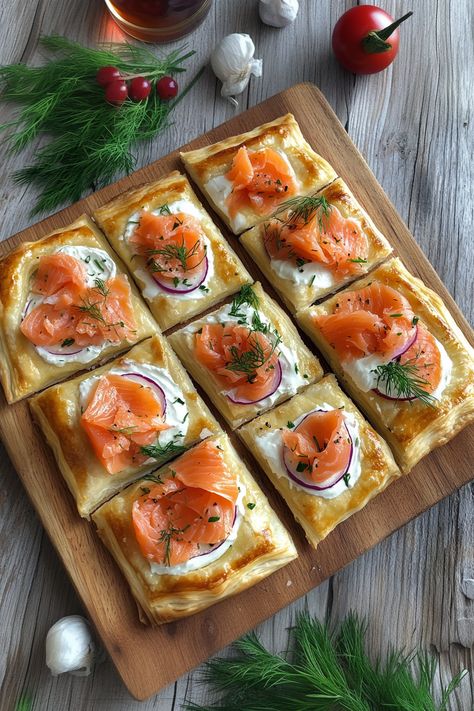 Create these Christmas Smoked Salmon Puff Pastry Pizza Squares for your next holiday party. Buttery puff pastry, creamy cheese, and savory smoked salmon make the perfect festive appetizer. Quick, elegant, and absolutely delicious. Save this recipe and wow your guests this holiday season! Smoked Salmon Puff Pastry Recipes, Puff Pastry Twists Savory, Puffy Pastry Appetizers, Savory Puff Pastry Recipes Appetizers, Breakfast Puff Pastry Recipes Savory, Puff Pastry Tart Savory, Smoked Salmon Puff Pastry, Savory Puff Pastry Recipes, Salmon Puff Pastry