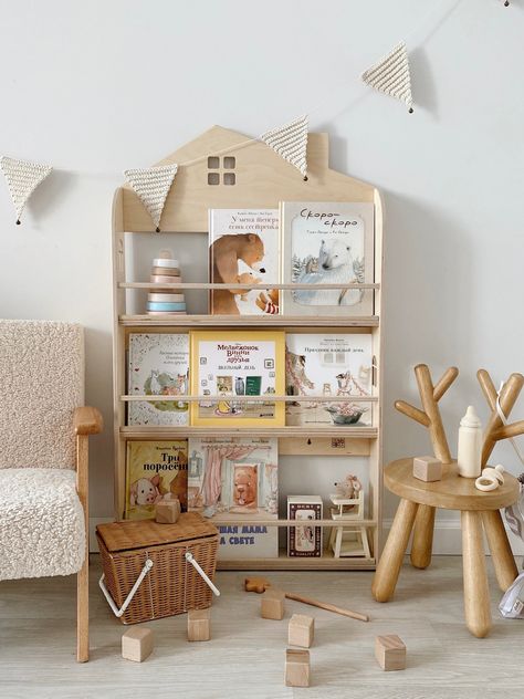 An original wall shelf for books in the shape of a house. Holds up to 50 books of medium thickness and different formats. Stoppers at the top and bottom prevent books from falling out. The top shelf is for the tallest books, the middle one is for small ones, and the bottom one is for A4 format. Height 106 cm, depth 10 cm, width 60 cm. With such a shelf, the child can easily find his favorite book and be able to get it out on his own. According to child psychologists, display book storaging is th Storage In Nursery, Bookshelf House, Montessori Bookcase, Childrens Shelves, Display Bookshelf, Montessori Bookshelf, Colorful Playroom, Desk Bookshelf, Nursery Bookshelf