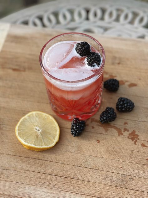 Glass sitting on a cutting board outside filled with a pinky red drink topped with blackberries. Aesthetic Pink Pictures, Blackberry Moonshine, Moonshine Drink Recipes, Blackberry Drinks, Moonshine Cocktails, Disney Inspired Recipes, Recipes Disney, Sour Drink, Cinnamon Simple Syrup