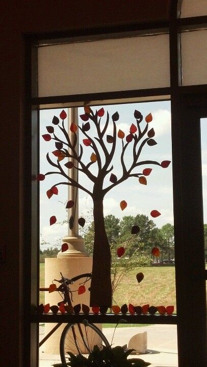 My version of the autumn tree. Coffee filters painted and cut in a leaf shape and brown paper as the tree. Viola! Autumn Window Drawing Ideas, Fall Themed Window Painting, Fall Tree Window Painting, Window Fall Paintings, Autumn Leaves Window, Library Decor, Leaf Shapes, Autumn Trees, Window Display