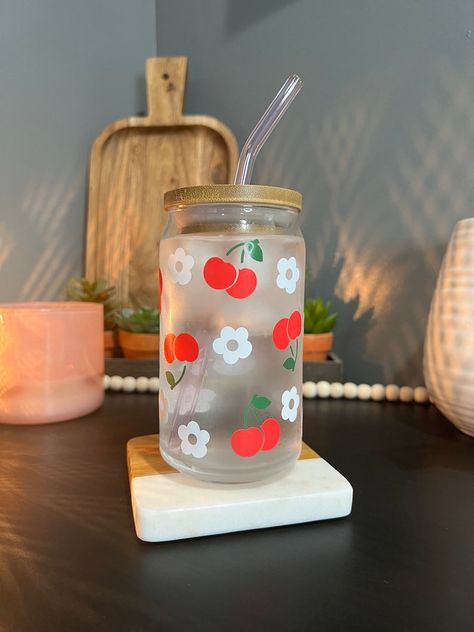 This 16 ounce glass cup is perfect for your favorite cold drinks! Featuring a charming cherry and flower pattern, the cherries change color when activated by cold. This design is made using premium vinyl and heat sealed for a durable finish. Cherry Glass Cup, Cherry Blossom Starbucks Cup, Floral Glass Cup, Flower Glass Coffee Cup, Kawaii Glass Cup, Cherry Flower, Flower Cup, Painted Cups, Pattern Glass