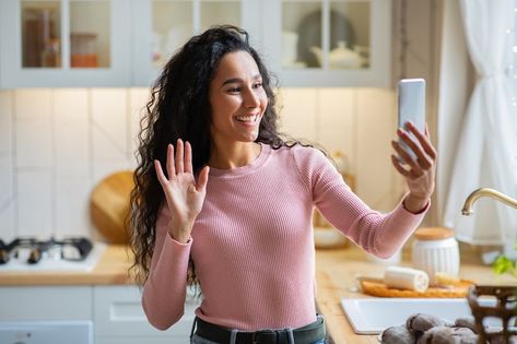 Cheerful Brunette Woman Making Video Call With Smartphone In Kitchen At Home, Enjoying Online Communication With Friends, Woman Waving Hand At Camera, Making Hello Gesture, Greeting Somebody Waving Hand, Online Communication, Brunette Woman, Anti Dandruff, Video Call, In Kitchen, Dandruff, Vintage Paper, Communication