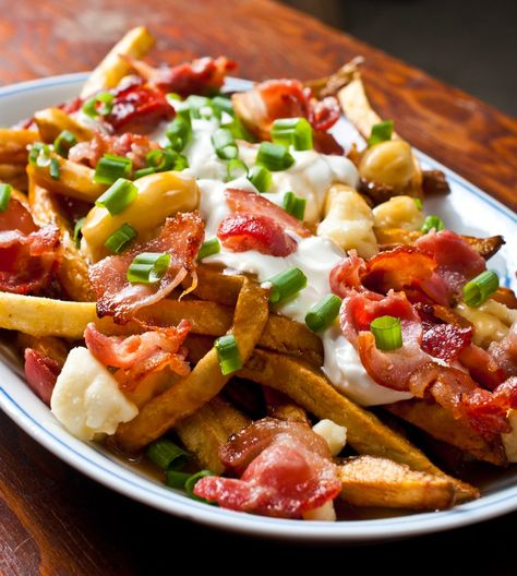 There's a great poutine shop in Toronto called Poutini's. My favourite poutine they is called The Works. It's bacon, sour cream and green onion on poutine. I... Poutine Recipe, Fries Recipe, Canadian Food, Poutine, Sweet And Sour Pork, French Fries, Green Onions, Potato Recipes, The Works