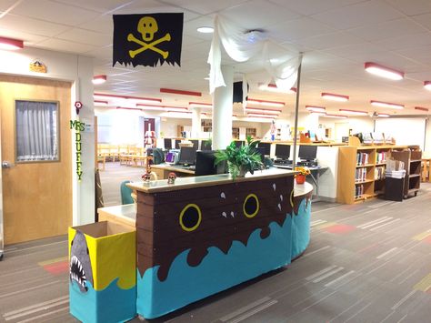 Pirate theme. Circulation desk decorated to look like a pirate ship. Mast secured in computer cable hole in desk. All materials pieced from felt. Tina Duffy's library/Longfellow Mid. Sch. S. A., Tx Vbs Shipwrecked, Snack Area, Vatican Flag, Pirate Decorations, Pirate Theme Classroom, Shipwrecked Vbs, Circulation Desk, Info Desk, Registration Table