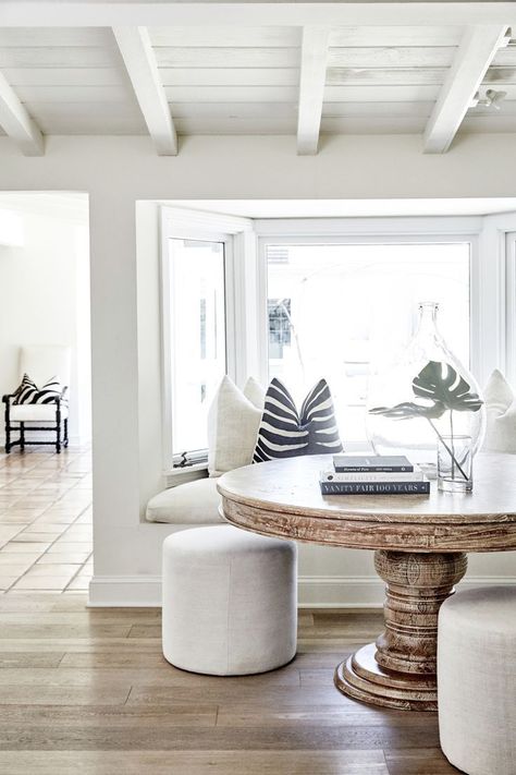 A Los Angeles Home That Perfectly Mixes Classic and Serene Dining Room With Round Table, Built In Bench Seating, Apartment Decoration, Minimalist Dining Room, White Dining Room, Large Window, Coastal Living Rooms, Coastal Living Room, Minimalist Home Decor