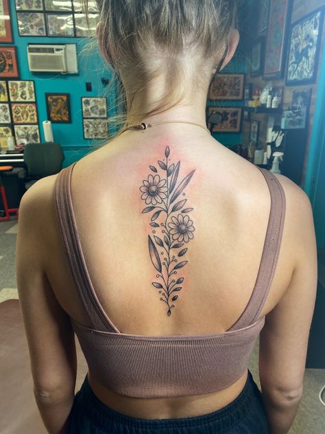 woman back tattoo, vine with flowers and leaves up spine Center Of Back Tattoo Women, Upper Back Spine Tattoo Women, Flower Upper Spine Tattoo, Daisy Flower Spine Tattoo, Wild Flower Back Tattoo, Flowers Down The Spine Tattoo, September Flower Spine Tattoo, Top Of Spine Tattoos For Women, Flower Bouquet Spine Tattoo