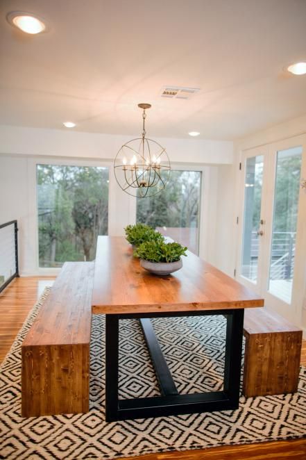 The dining room features a table custom made by Clint Harp. The table's design features a black metal base that ties in with the new metal railing and combines the modern look of steel with the warmth and earthiness of wood. Modern Farmhouse Dining Room Decor, Farmhouse Dining Rooms Decor, Modern Farmhouse Dining Room, Modern Farmhouse Dining, Table Rug, Coastal Living Rooms, Farmhouse Dining Room, Room Decorations, Farmhouse Dining