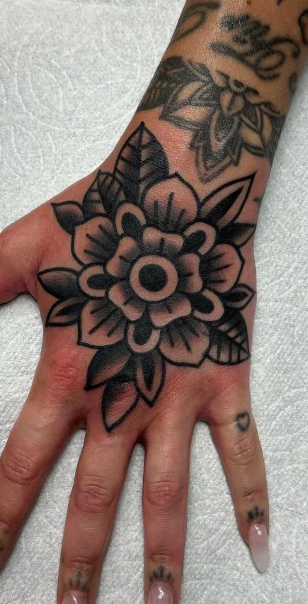 100 Hand Tattoos For Women With Style - Tattoo Me Now Hand Tattoo American Traditional, American Traditional Tattoos Hands, Am Trad Tattoo, Lily Tattoo Hand, American Trad Hand Tattoo, Black And Grey Hand Tattoos, Irish Hand Tattoos, Hand Tattoos For Women Traditional, Leg Sleeve Women Tattoo