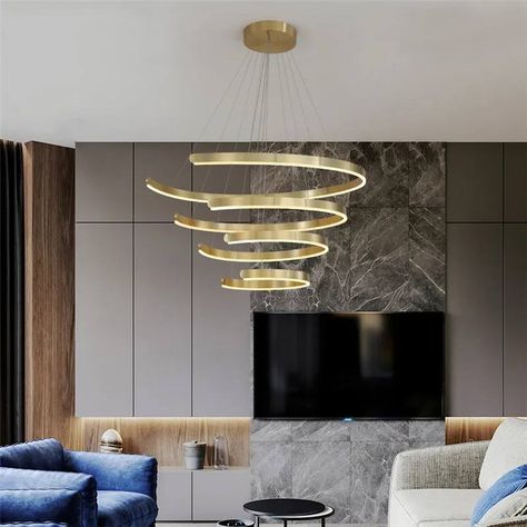 A sculpture of light and style,the contemporary stainless steel pendant light gracefully descends from the living room ceiling,its sleek curves and polished finish reflecting the ambiance with a touch of modern sophistication. Chandelier For Living Room, Bathroom Pendant, Staircase Chandelier, Rectangle Chandelier, 2 Rings, Gold Chandelier, Dining Room Chandelier, Modern Light Fixtures, Adjustable Lighting