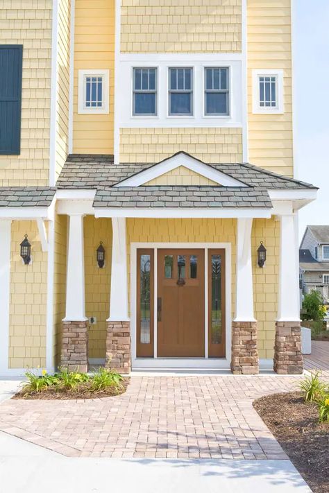 Light Yellow Houses Exterior, Yellow House Door Color Ideas, Yellow House With Stone Accent, Yellow Beige House Exterior, Yellow Front Door Tan House, Yellow And Brown House Exterior, Brown House Yellow Door, Yellow Vinyl Siding House, Light Yellow House