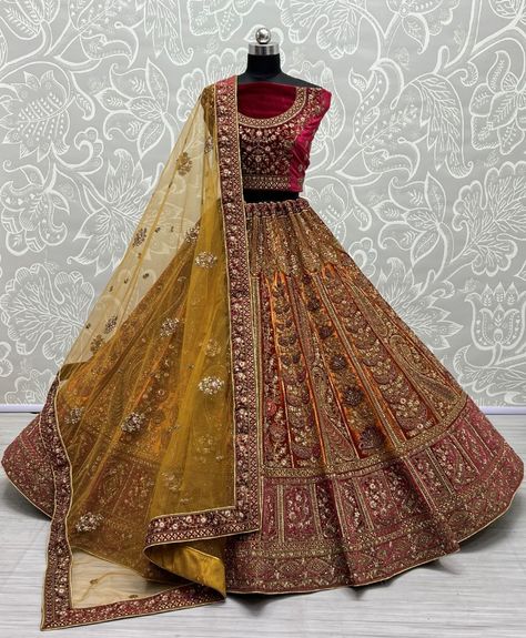 This stunning lehenga choli set features a beautiful combination of golden and red colors, perfect for any festive occasion or wedding. The intricate embroidery work and sequin detailing add a touch of elegance and sophistication to the outfit. The set comes with a net dupatta to complete the look. Most Beautiful Lehenga, Bridal Lehenga Maroon, Mustard Lehenga, Wedding Gifts Indian, Maroon Lehenga, Beautiful Lehenga, Velvet Lehenga, Wedding Sherwani, Neck Deep