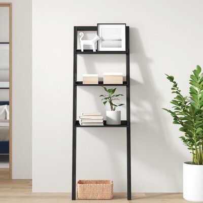 Tuck away titles or show off your favorite decorative pieces with this leaning ladder bookcase! It's crafted from a blend of solid and engineered wood with a black finish and features a streamlined, ladder-like design that leans against your walls for a modern look in any space. This piece features two slender shelves and one wider one, so it's great for both organization and display. Measuring 69' H x 23'' W x 19.69'' D overall, it's a call option that's ideal in narrow spaces. George Oliver | Leaning Ladder, Black Bookcase, Office Bookcase, Ladder Bookcase, Engineered Wood, Decorative Pieces, Brown And Grey, Bookcase, Black And Brown